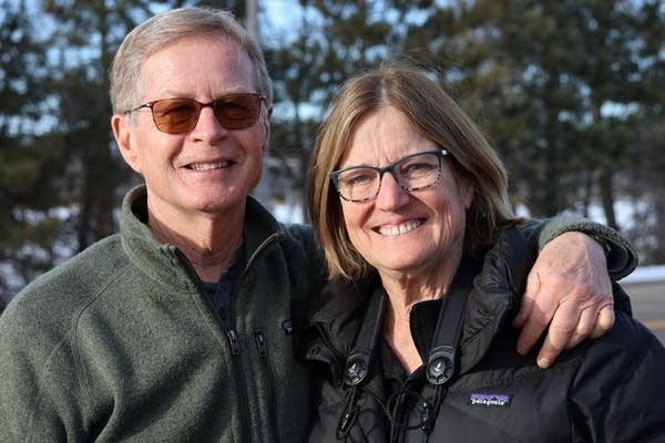 Two people posing for pic outside 