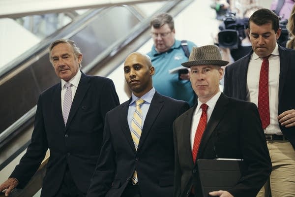 Mohamed Noor is trailed by reporters.