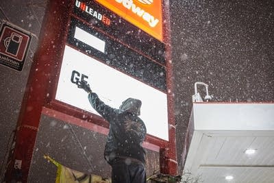 A man adds lettering to a sign