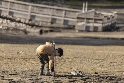 A boy walks onto a dry lake bed.