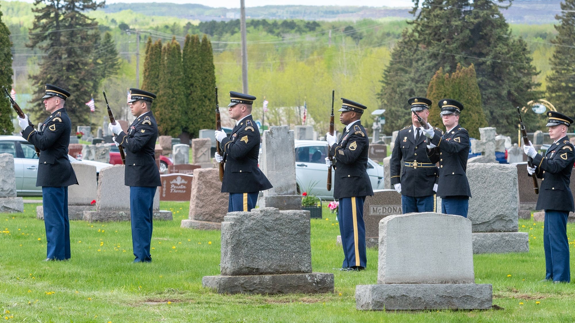 Servicemembers perform a rifle salute to honor Dante Tini