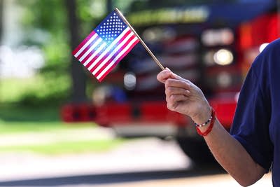An onlooker holds an American flag