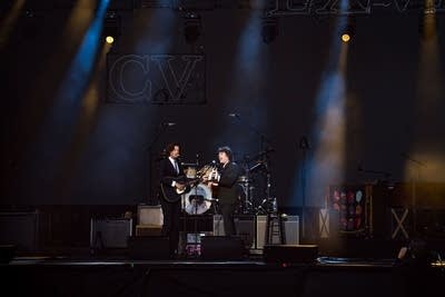 Two musicians performing on an outdoor stage