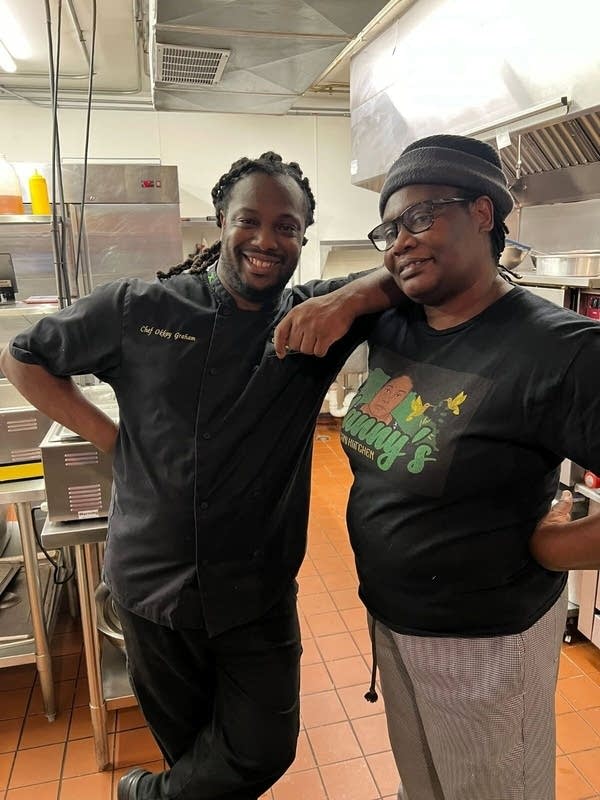 two people posing for photo in a kitchen