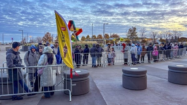 A line of people outdoors at sunrise