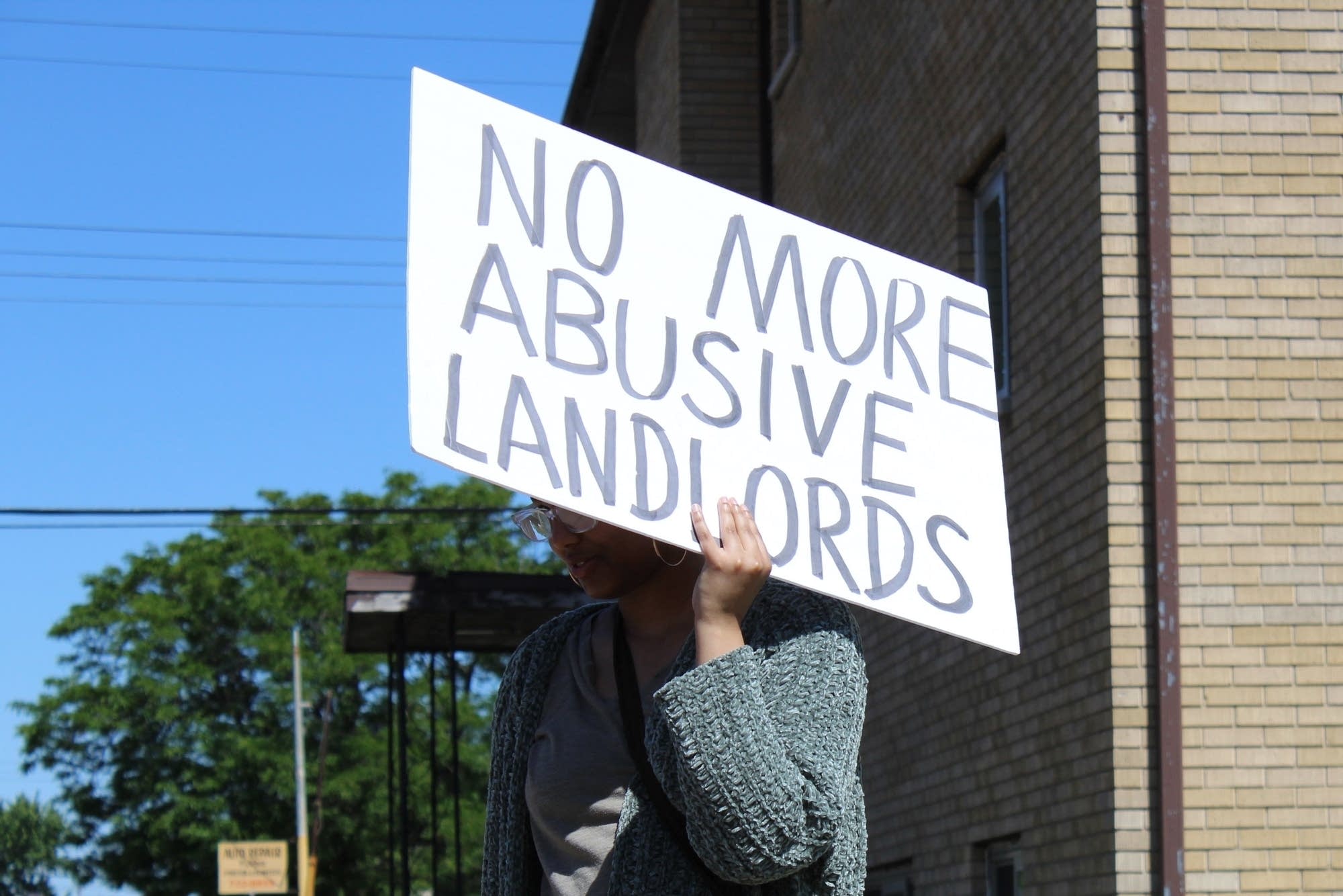 Kaaha Kaahiye holds a sign protesting gentrification.