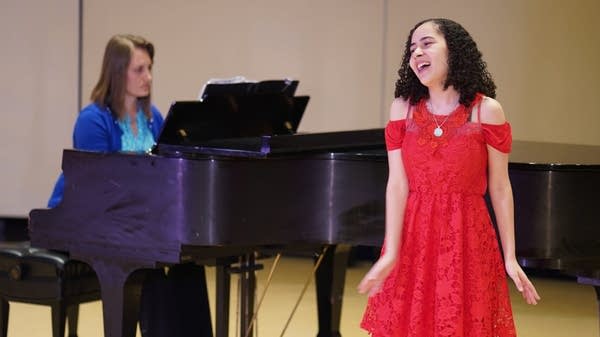 Poster A young girl sings in front of a grand piano