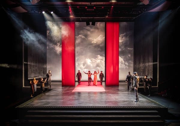 The cast stands on a stage.