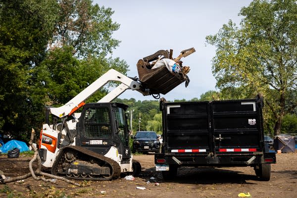 Debris is loaded into a trailer by a Bobcat