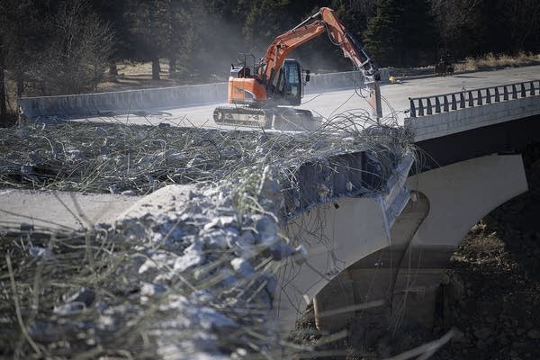 A large jackhammer chips away at concrete