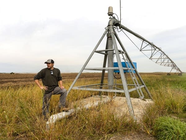 A man stands near an irrigation system