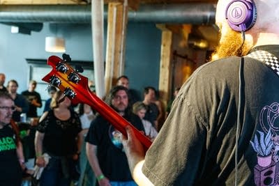 A musician plays bass in a small music venue