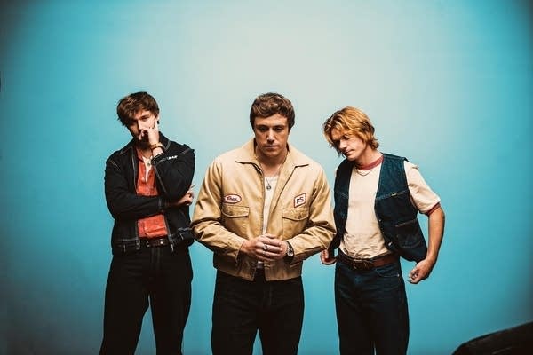 Three guys stand together for a studio portrait