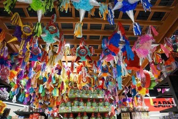 Piñatas hang from a pergola near the ceiling.