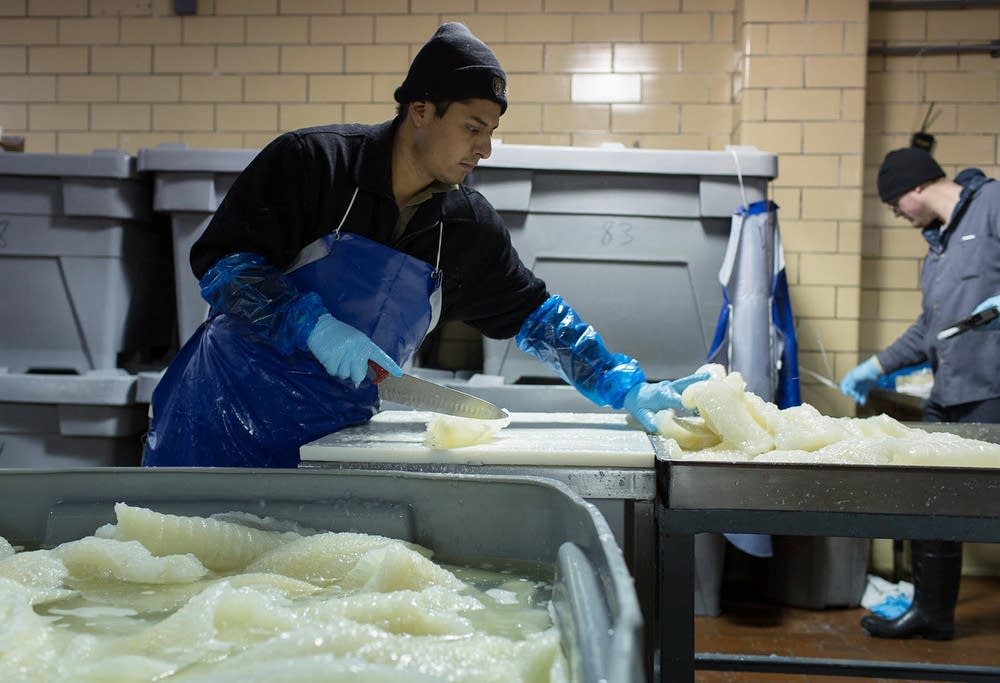 Pieces of lutefisk are cut and weighed