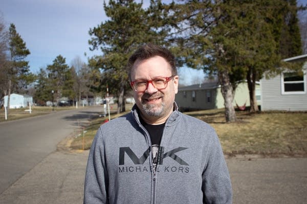 A man stands in a neighborhood.