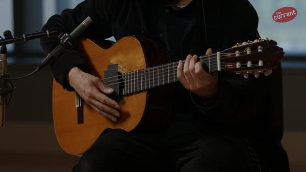 A musician plays guitar in a recording studio