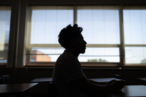 A silhouette of a student in a classroom