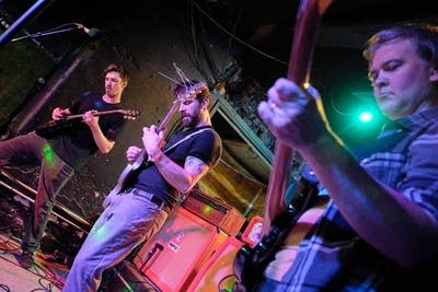 Three musicians performing onstage