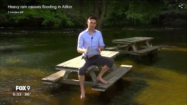 Reporters standing in water