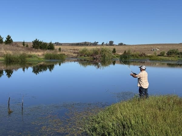 Loren Poncia fishes in a pond.