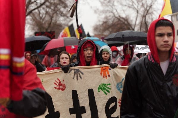 People hold a sign and walk