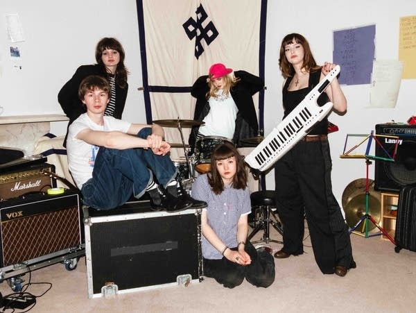 Five people pose for a photo with instruments.