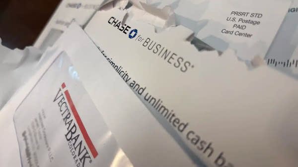 A pile of mail registered to fraudulent businesses sits on Jarrett Taylor's kitchen table. He says the volume can feel overwhelming.