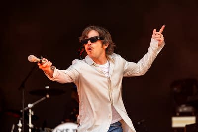 Cage the Elephant performing on an outdoor stage.