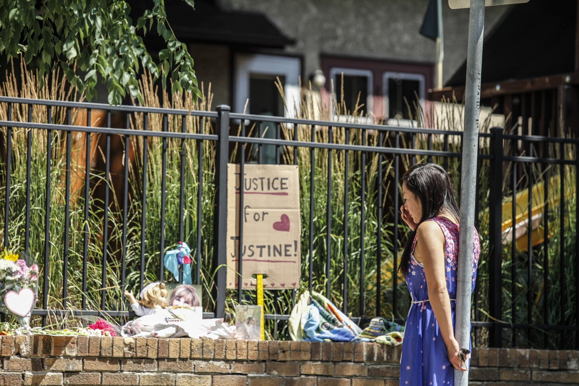 A neighborhood resident stops by the memorial for Justine Ruszczyk.