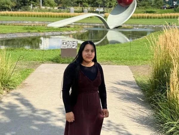 A woman poses in front of Spoon and Cherry in Minneapolis