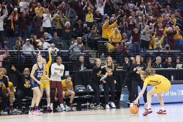 Members of a team rise from a bench and clap