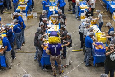 People stand at tables and pack meals 1