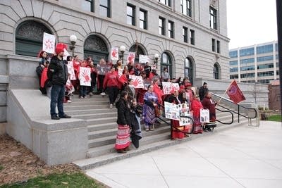 Demonstrators standing on steps ouside 