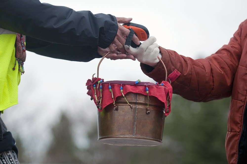Camille Gage passes the container of water