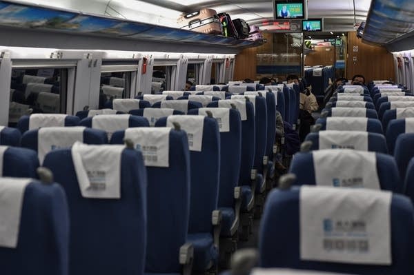 People wearing protective facemasks sit on a train usually full with passengers ahead of the Lunar New Year. (Photo by HECTOR RETAMAL/AFP via Getty Images)