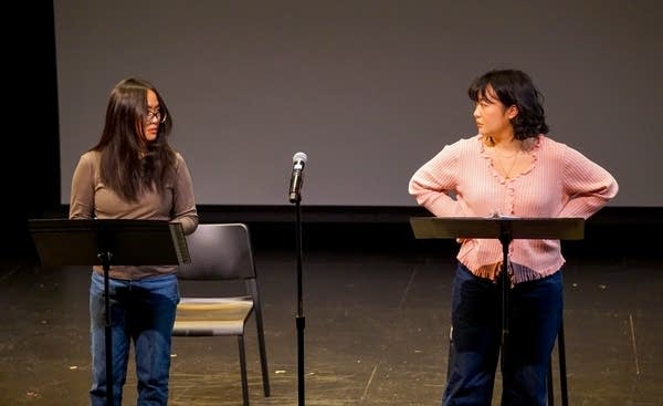 Two people standing by microphone