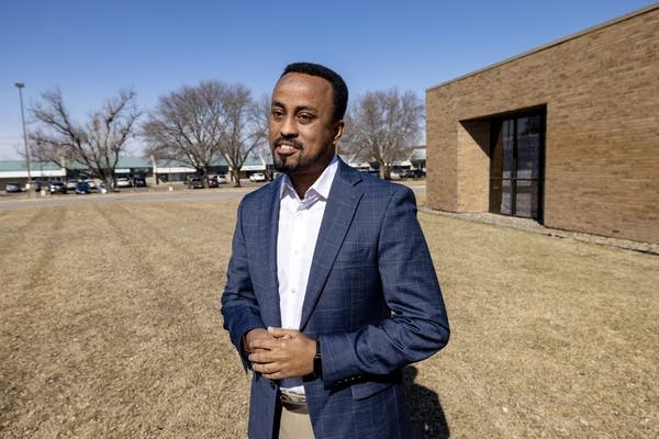 A man in a blue suit poses for a photo-3