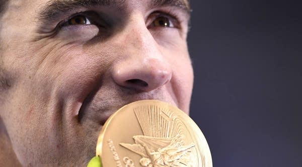 USA's Michael Phelps kisses his gold medal on the podium after Team USA won the Men's 4x200m Freestyle Relay Final during the Rio 2016 Olympic Games.