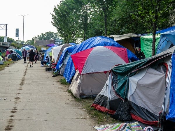 Dozens of tents are crammed into a patch of grass