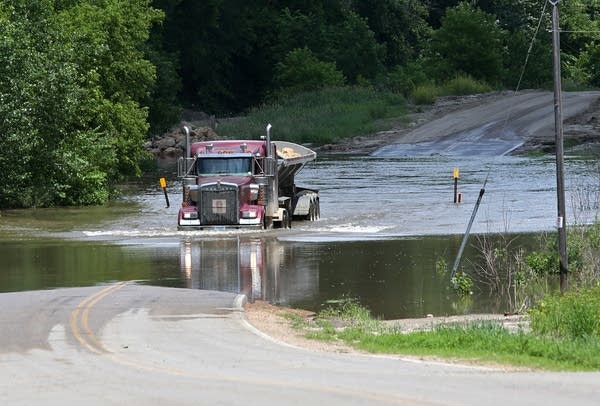 A load of rocks heads into town on flooded roads.