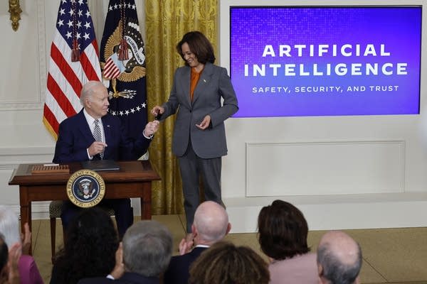 WASHINGTON, DC - OCTOBER 30: U.S. President Joe Biden hands Vice President Kamala Harris the pen he used to sign a new executive order regarding artificial intelligence during an event in the East Room of the White House on October 30, 2023 in Washington, DC. President Biden issued the executive order directing his administration to create a new chief AI officer, track companies developing the most powerful AI systems, adopt stronger privacy policies and "both deploy AI and guard against its possible bias," creating new safety guidelines and industry standards. 