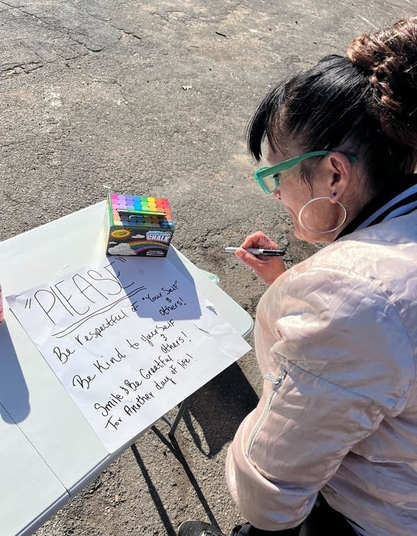 A person writes on a poster