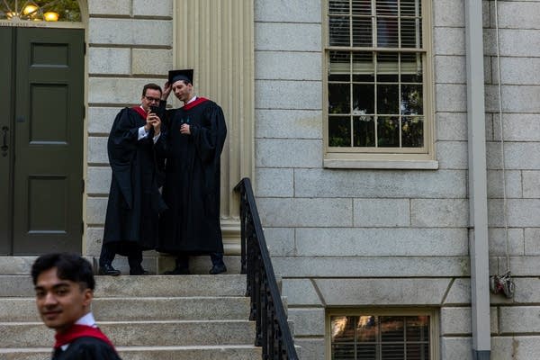 Students take a selfie in their cap and gown. 