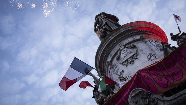 People celebrate the results of France's second round of elections at Le Monument a la Republique on Sunday.