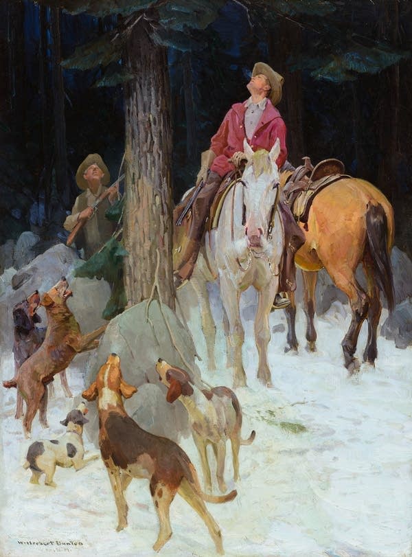 A painting shows a group of five dogs barking and looking up a tall tree. Two cowboys, one on horseback, the other on the snowy ground, both look up the tree. Whatever is up the tree remains out of sight.