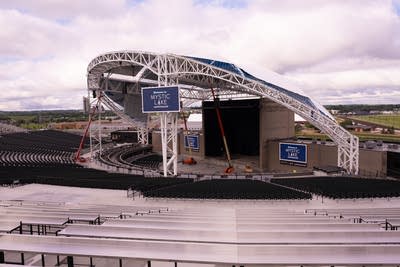 An outdoor amphitheater with a stage under a partial roof.