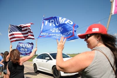 A Trump supporter holds up four fingers, chanting "Four More Years."