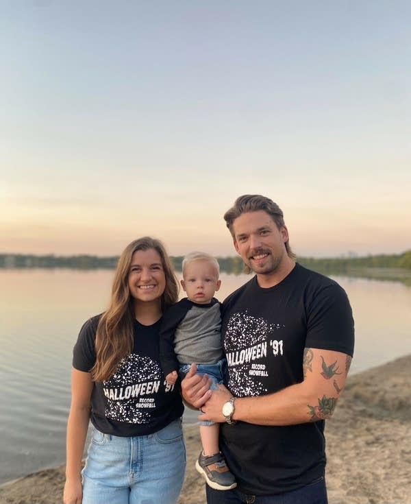 A family of three pose for a photo. 