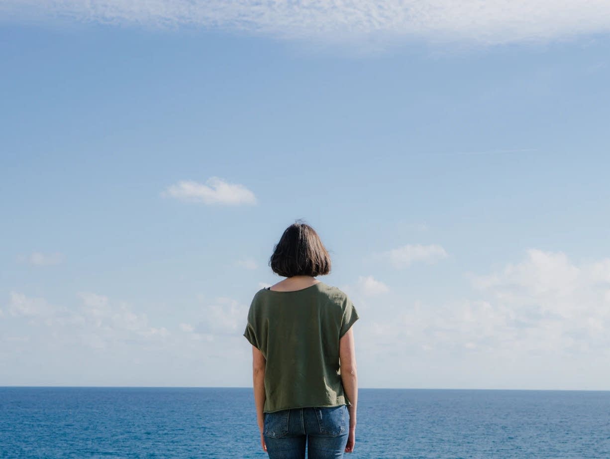 A woman faces the horizon.
